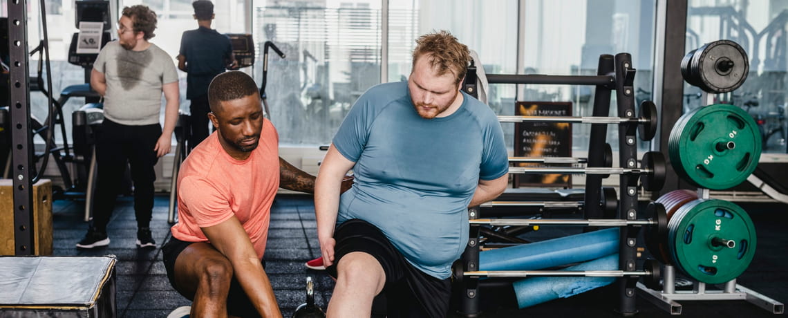 Übergewichtiger Mann beim Training im Fitnessstudio.